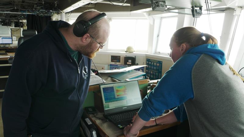 Listening to whale calls on the ship's bridge and the direction of the source. The range of the sonobuoy to the ship is about 15km. - photo © NOAA Fisheries