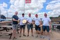 Richard Lewis, Bosham SC Commodore presenting the Bosham Plate to the winner of the 2025 Finn Open, Mike De Courcy alongside Martin Hughes, winner of the Amoeba Cup for first Classic, Shaun Hopkins, third place and John Mackie, second place © Paul Thorpe