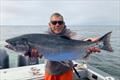 Oregon angler Jim Anderson displays a wild Oregon Coast coho salmon that he caught in the popular coastal fishery for the rebounding species. Although still listed under Endangered Species Act, wild species is productive enough to support a sport fishery