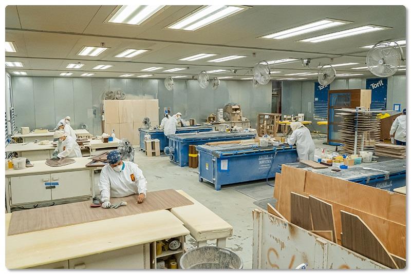 Like every work area in the plant, the sanding booth in the Mill teems with concentrated energy. - photo © Viking Yachts