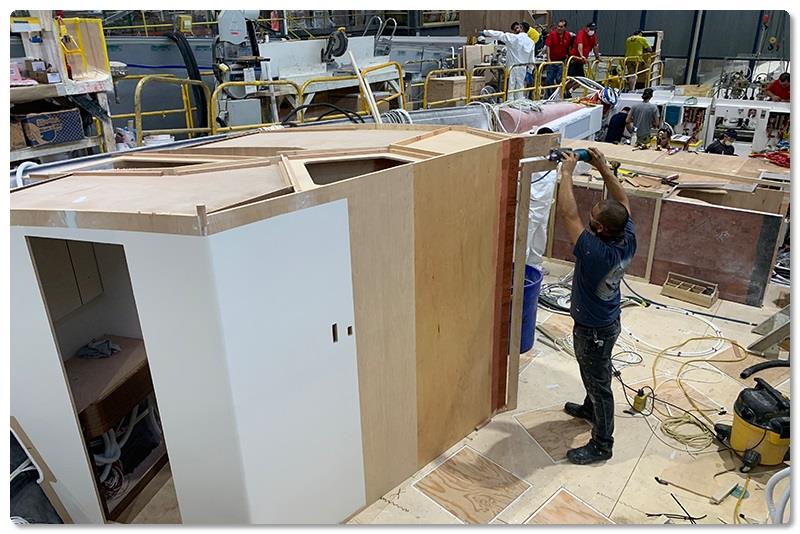 The master and forward VIP head module has been positioned in the forepeak area; Carpenter Martin Torres is shown removing a temporary support structure for the unit. - photo © Viking Yachts