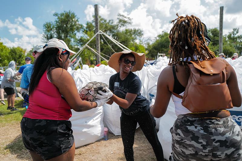 Volunteers gather bags of oyster shells to help protect ancient burial mounds belonging to the Pointe-au-Chien Tribe photo copyright Coalition to Restore Coastal Louisiana taken at  and featuring the Fishing boat class