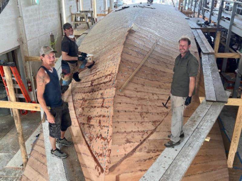 Hull #11 - Flipper, Scott, and Brian applying the final planks - photo © Michael Rybovich & Sons
