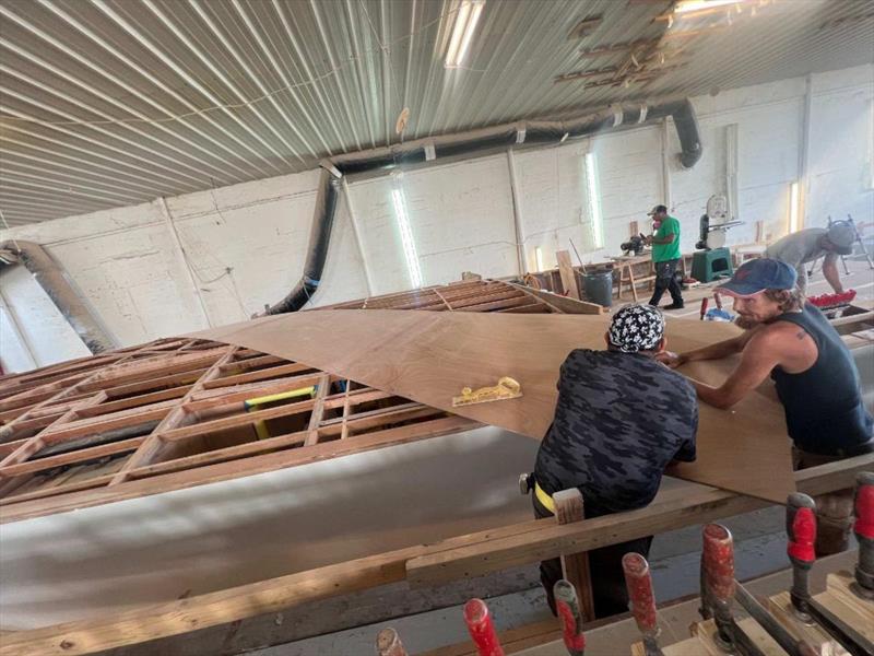 Hull #11 - Sal and Flipper fitting first foredeck plank - photo © Michael Rybovich & Sons