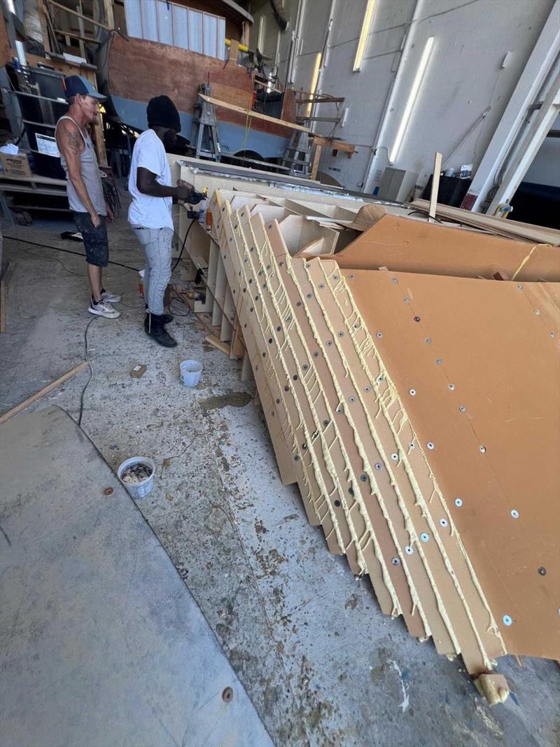Hull #11 - Flipper and Sherwayne gluing on the Divinycel - photo © Michael Rybovich & Sons