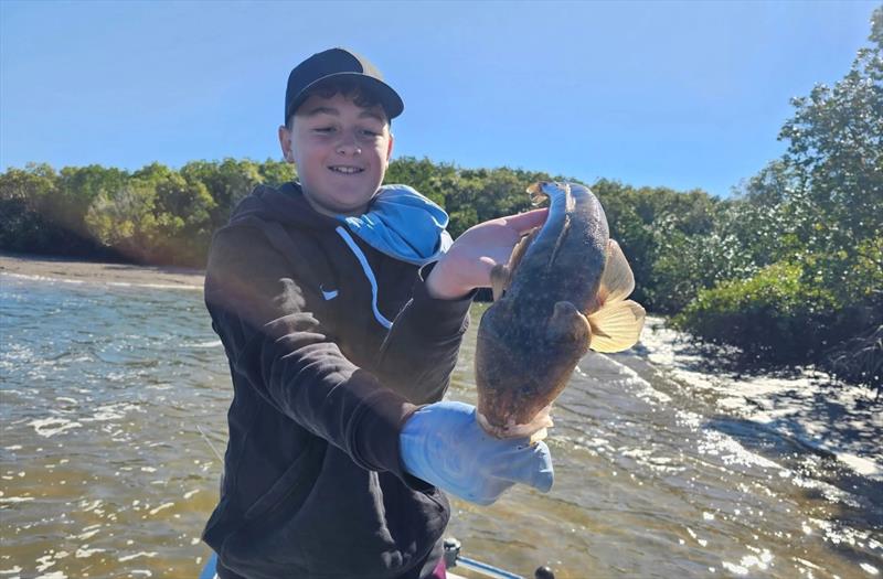 Young Mr Green with a lovely flathead caught in cold and windy conditions - photo © Fisho's Tackle World Hervey Bay