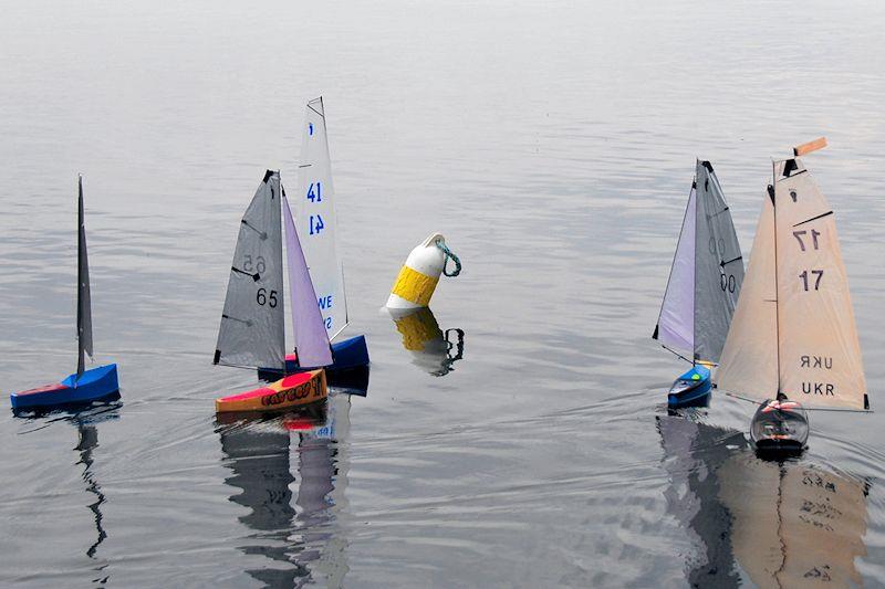 Whole fleet arrives at the first mark together - Footy class Videlo Globe at Frensham Pond - photo © Roger Stollery