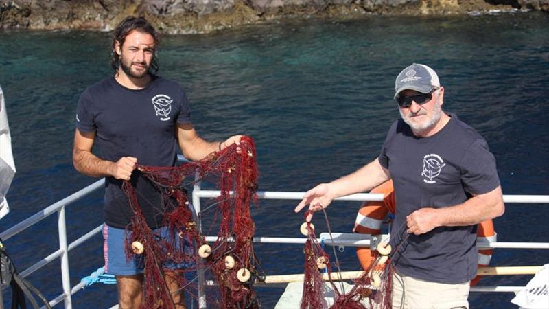 Stefano Marsala, a volunteer with Sea Shepherd, Italy, pulls up an illegal fishing net with WHOI scientist Alex Bocconcelli in the Aeolian Islands. - photo © Nicole El Haddad / Woods Hole Oceanographic Institution